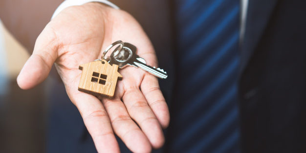 Close Up view home keys agent hand giving new owner | Legal Advice Guru