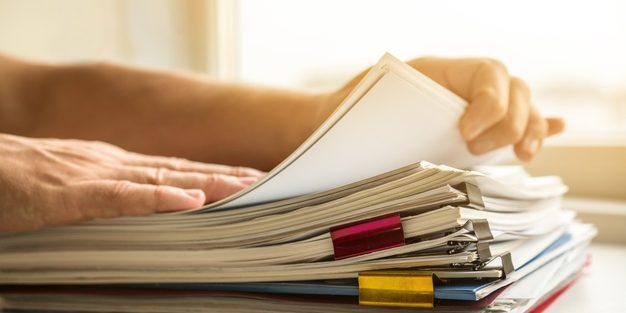 side view man arranging business files | Legal Advice Guru